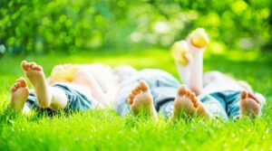 Three kids lying on beautiful grass.